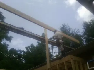 Carpenter setting a ridge beam over a new addition frame — Ice Dam Removal by Roofing Brothers in Mcmechen