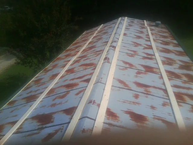 Rusted metal roof panels with new wood purlins before replacement — Storm Damage Roof Repair in Mcmechen by Roofing Brothers