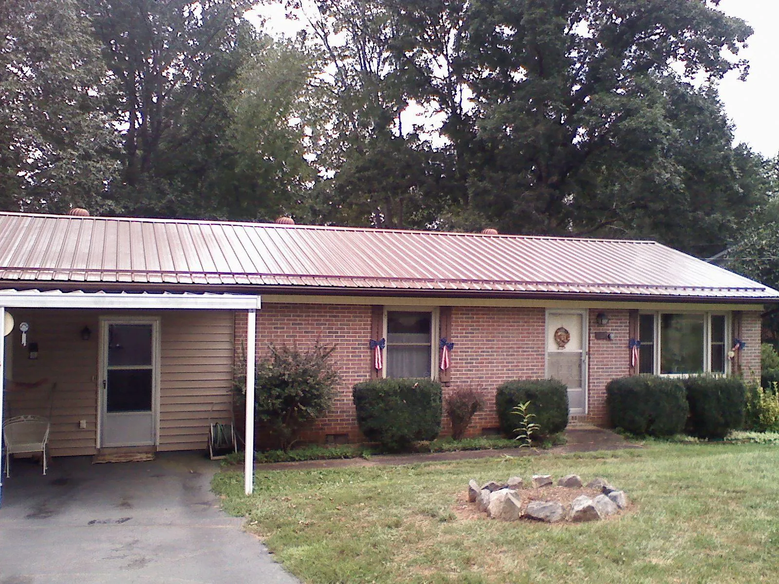 Bronze metal roof and carport on a brick ranch home — Roof Repair work by our crew in Mcmechen