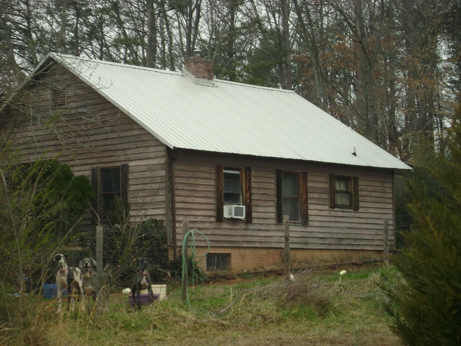 White metal roof on an old wood sided farmhouse, from a Metal Roof Installation job in Mcmechen